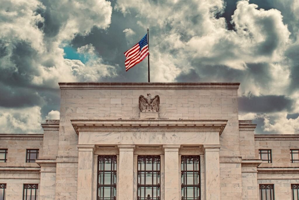 Bandeira dos Estados Unidos sobre o edifício do Federal Reserve, ilustrando a dívida americana e o planejamento financeiro pessoal.